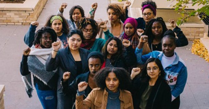 Women holding fists up in WFMN